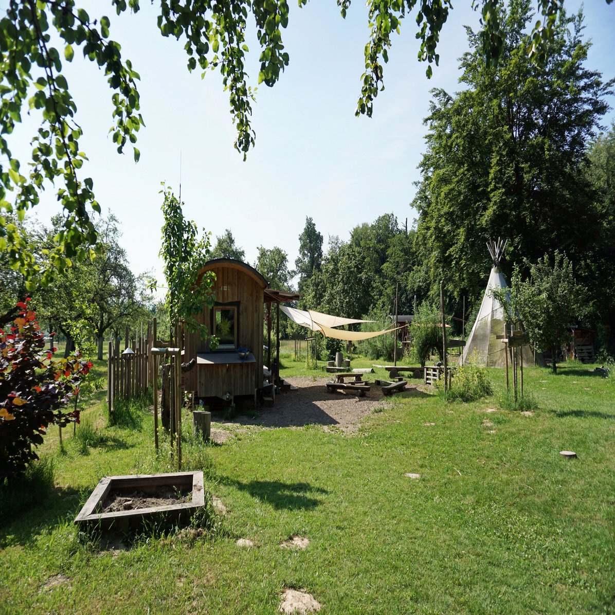 Waldkindergarten Schurwaldspatzen Außenbereich mit Sandkasten, Sitzmöglichkeiten und Tipi