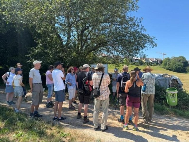 Viele Personen der Bürgerstiftung stehen auf einem Feldweg vor einem Baum