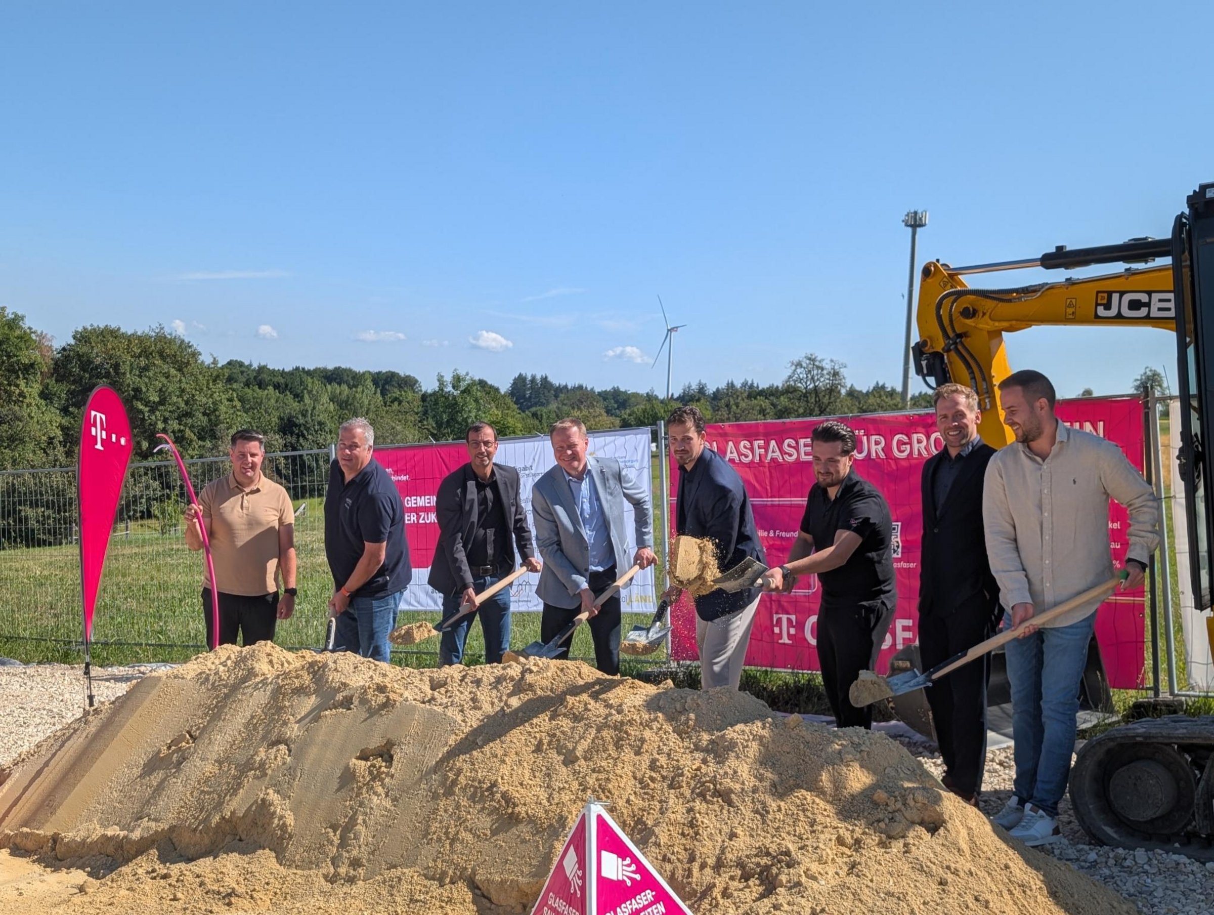 Baustart Glasfaser für bislang unterversorgte Adressen - Acht Männer mit dem symbolischen Spatenstich, darunter Mitarbeiter der Telekom und Bürgermeister Simon Schmid sowie Ortsbaumeister Marlon Bier der Gemeinde Baltmannsweiler