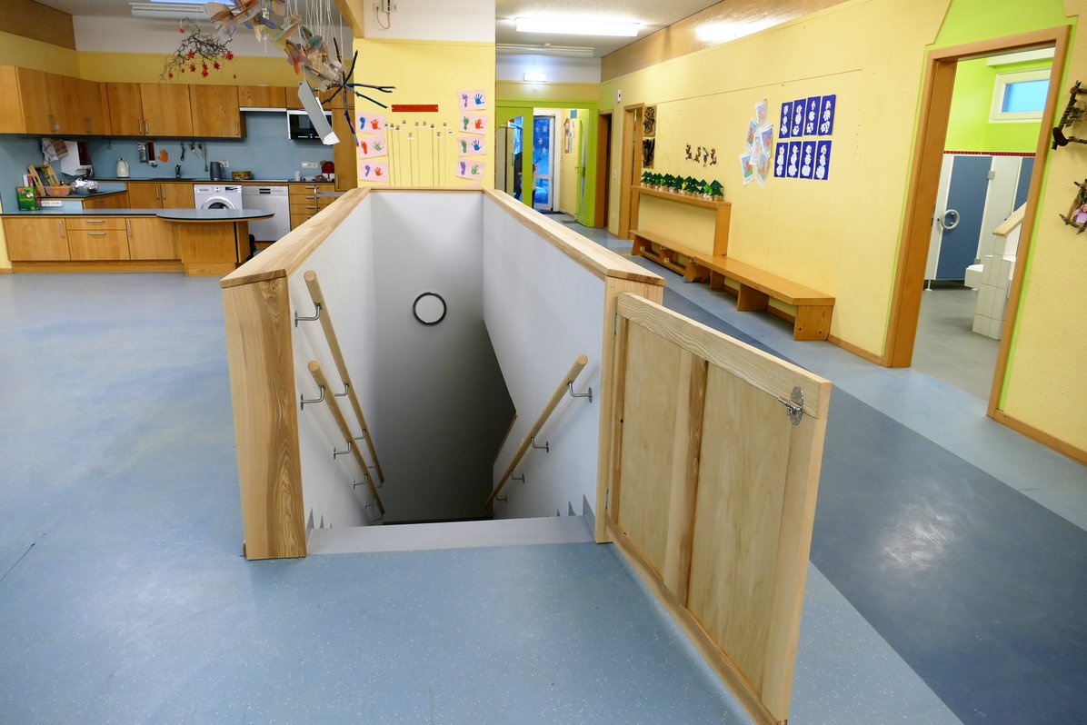 Innenbereich der Kindervilla Kunterbunt Baltmannsweiler - zentral ist die Treppe in der Mitte, hinten links ist die Küche und rechts von der Treppe ist das Badezimmer